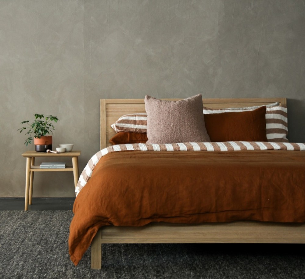 Bedroom with terracotta linen bedding and oak bed frame