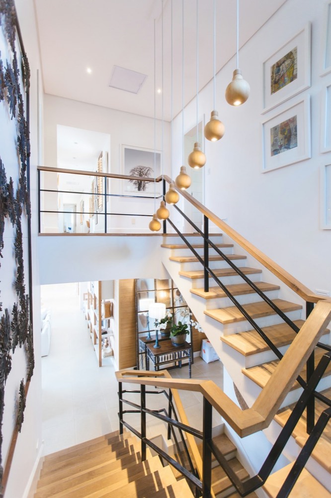 Double height stairwell with gold pendant lights